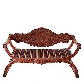 Love seat. Origen europeo. Siglo XX. Estilo español. En talla madera. Tapicería de tela con diseño lineal.