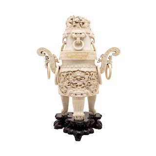 URNA. CHINA, SIGLO XIX. Talla en marfil decorada con dragones, leones y anillos. Cuenta con dos asas y una tapa desmontable. 36 cm alt.