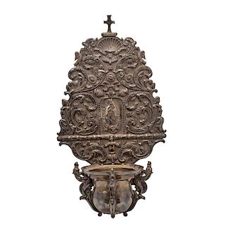 PILA PARA ADOSAR. MÉXICO, SIGLO XX. Lámina de plata repujada, marcada CENART, decorada con una Virgen de Guadalupe. 56 x 31 cm. 1,180 g