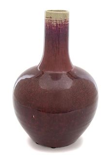 A Chinese Sang de Boeuf Glazed Bottle-form Vase Height 12 x diameter 7 inches.