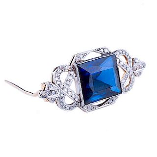 Prendedor. Elaborado en oro de 18k. Decorado con una gema de color azul y acentos de diamantes. Peso: 10.2 g.