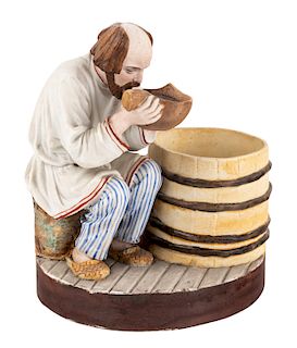 A RUSSIAN PORCELAIN FIGURE OF A MAN DRINKING, POPOV PORCELAIN FACTORY, CIRCA 1850S-1870S