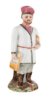A RUSSIAN PORCELAIN FIGURE OF A MAN CARRYING BREAD, PRIVATE PORCELAIN FACTORY, MID-19TH CENTURY