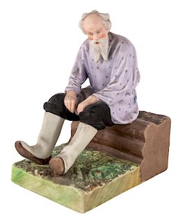 A RUSSIAN PORCELAIN FIGURE OF AN OLD MAN ON A IZBA BENCH, GARDNER PORCELAIN FACTORY, MOSCOW, LATE 19TH CENTURY