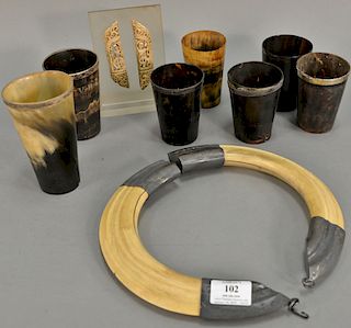 Horn tusk group including group of seven horn cups (most with silver rim), boar tusk necklace, and carved bone in the form of skelet...