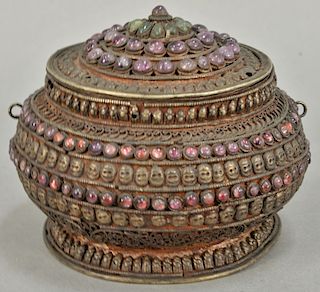Early filigree covered box mounted with pink and green beads and skull and skeleton embossed design. ht. 4 1/2 in., dia. 4 in. 
Prov...