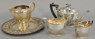 Five piece sterling silver lot to include a three piece tea set, repousse plate and creamer. 27.3 t oz.