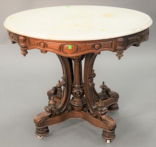 Oval Victorian walnut marble top table. ht. 28 in., top: 25" x 36"  