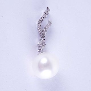 Dije con una perla en oro blanco 14K. Pela cultivada oval color blanco y acentos de diamantes. Peso: 1.9g.