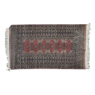 Tapete de oración. Siglo XX.Estilo Bokhara. Anudado a mano en fibras de lana y algodón. Decorada con diseños romboidales y geométricos.
