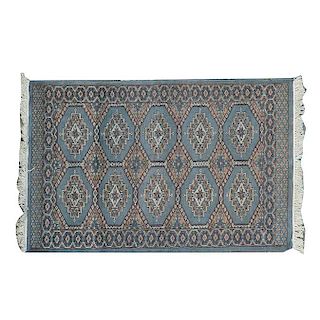 Tapete. Siglo XX. Estilo Bokhara. Anudada en fibras de lana y algodón. Decorada con diseños romboidales sobre fondo gris.