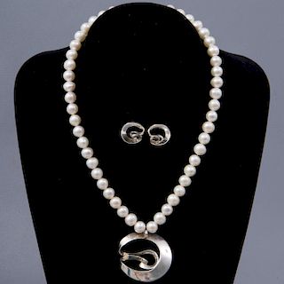 Collar y par de broqueles. Elaborado con 48  perlas cultivadas color blanco. 10 mm. Broche de plata. Peso: 56.4g.