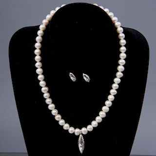 Collar con dije y par de broqueles. Elaborados con 50 perlas cultivadas color blanco. 10 mm. Broche de plata. Peso: 53.6g.