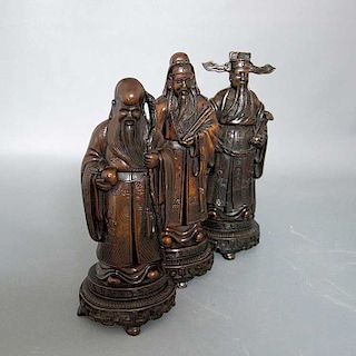 Lote de 3 figuras decorativas. Origen oriental. Siglo XX. Elaboradas en resina color marrón. Consta de 2 sabios y emperador.