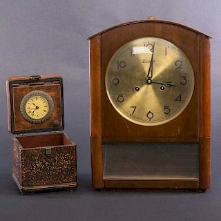 Lote de 2 relojes. SXX. Cajas de madera tallada. Con detalles de metal dorado. Consta de reloj de escritorio y reloj de pared.