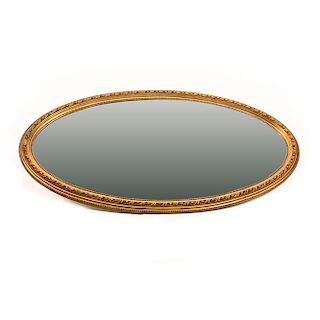 Espejo. Siglo XX. Diseño oval. Con marco de madera dorada y luna biselada. Decorado con molduras.