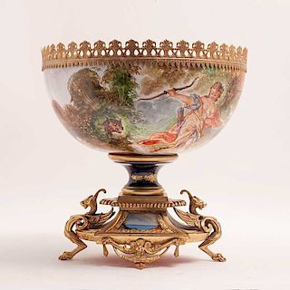 Centro. Francia, principios del siglo XX. Estilo Imperio. En porcelana tipo Sévres. Con aplicaciones de bronce dorado y metal.