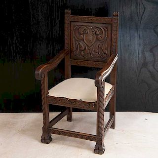 Sillón frailero. Siglo XX. Elaborado en madera tallada. Con respaldo, asiento en textil color beige y soportes tipo garra.