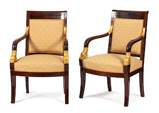 A Pair of French Empire Style Mahogany and Parcel Gilt Armchairs Height 35 1/4 x width 23 x depth 21 inches.