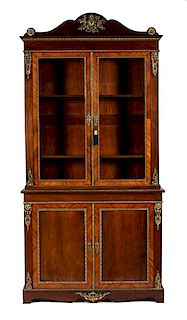 A French Empire Gilt Metal Mounted Kingwood and Mahogany Bookcase Height 101 x width 50 x depth 21 inches.