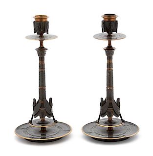 A Pair of Egyptian Revival Ebonized and Gilt Bronze Candlesticks Height 10 1/2 x diameter 5 inches.