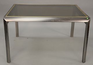 Expanding dining table by Brueton, in brushed metal with a brass plated trim detail. ht. 30 in., top closed: 41 1/2" x 52", top open...