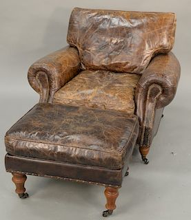 Leather upholstered chair and ottoman. ht. 34 in., wd. 41 in.