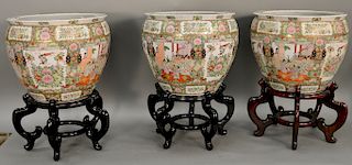 Three large rose medallion porcelain urns on stands. ht. with stand 25 1/2 in., ht. without stand 15 1/2 in.