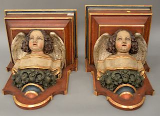 Pair large carved wood figural bracket shelves, each having carved winged cherub bust, carved wood painted gesso. ht. 19 in., wd. 17...