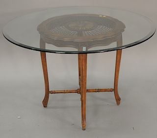 Glass top table with caned table base. ht. 29 in., dp. 46 in.
