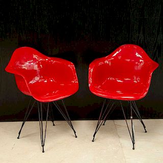 Sobre el diseño de Charles y Ray Eames. Par de sillones Eames. Estructura de metal con moldeado de fibra de vidrio. Piezas: 2