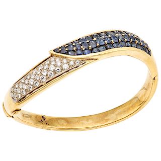 A sapphire and diamond 18K yellow gold bangle bracelet.