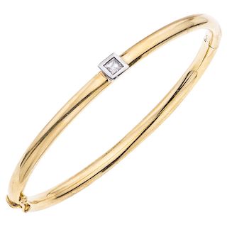 A diamond 18K yellow and white gold bangle bracelet.