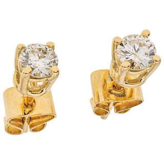A diamond 18K and 14K yellow gold pair of stud earrings.