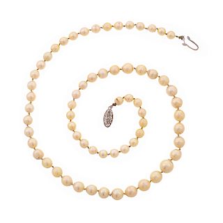 Collar con perlas y plata. 64 perlas cultivadas de 5 mm color crema. Broche de plata, forma oval. Peso: 34.3 g.