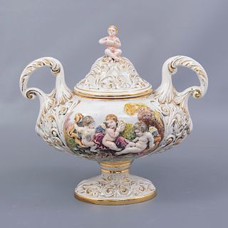 Sopera. Italia. Siglo XX. Elaborada en porcelana Capodimonte. Decorada con elementos orgánicos, esmalte dorado y amorcillos.