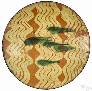 Pennsylvania redware charger, ca. 1800, with yellow wavy lines and green splashes, 14'' dia.