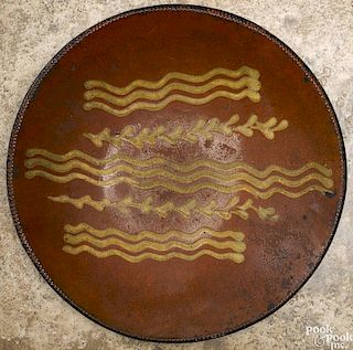 Redware charger, 19th c., with yellow slip decoration, 12 1/8'' dia.