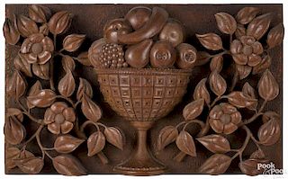 Relief carved walnut plaque, late 19th c., of a compote of fruit flanked by floral garlands