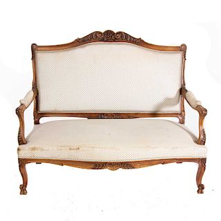 Love seat. Francia. Siglo XX. Estilo Luis XV. En talla de madera de nogal. Con tapicería de tela color beige.