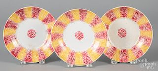 Three red and yellow rainbow spatter saucers