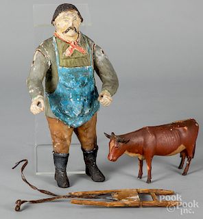Carved and painted figures of a man and cow