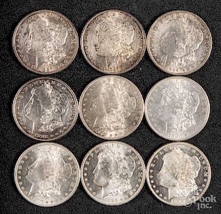 Nine Morgan silver dollars.