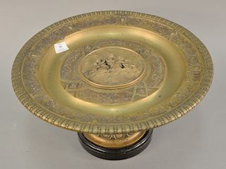 Victorian figural bronze compote charger having central plaque with three putti figures and dragon (cracked), and foliate molded rim 