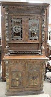 Large carved oak cabinet having colored leaded glass door top. ht. 90 in., wd. 43 in.