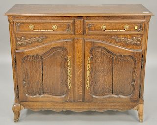 Carved oak server with two doors. ht. 39 in., wd. 47 in. Provenance: From an estate in Lloyd Harbor, Long Island, New York