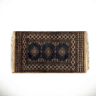Tapete. Pakistán, siglo XX. Estilo Bokahara. Elaborado en fibras de acrílico, lana y algodón. Decorado con motivos geométricos.