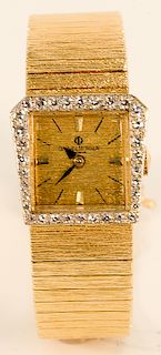 Baume & Mercier 14 karat gold ladies wristwatch having 14 karat gold band and diamond surround.  19.5x20.5mm, 49.7 grams total weight