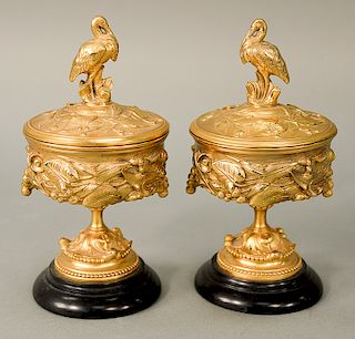 Pair of French gilt bronze compotes with cover, each having molded leaf decoration with crane finial on the cover, both resting on b...