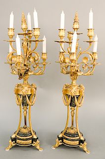 Pair of large gilt bronze candelabra, seven light with scrolling leaf arm supports over central support having ram heads, on granite...